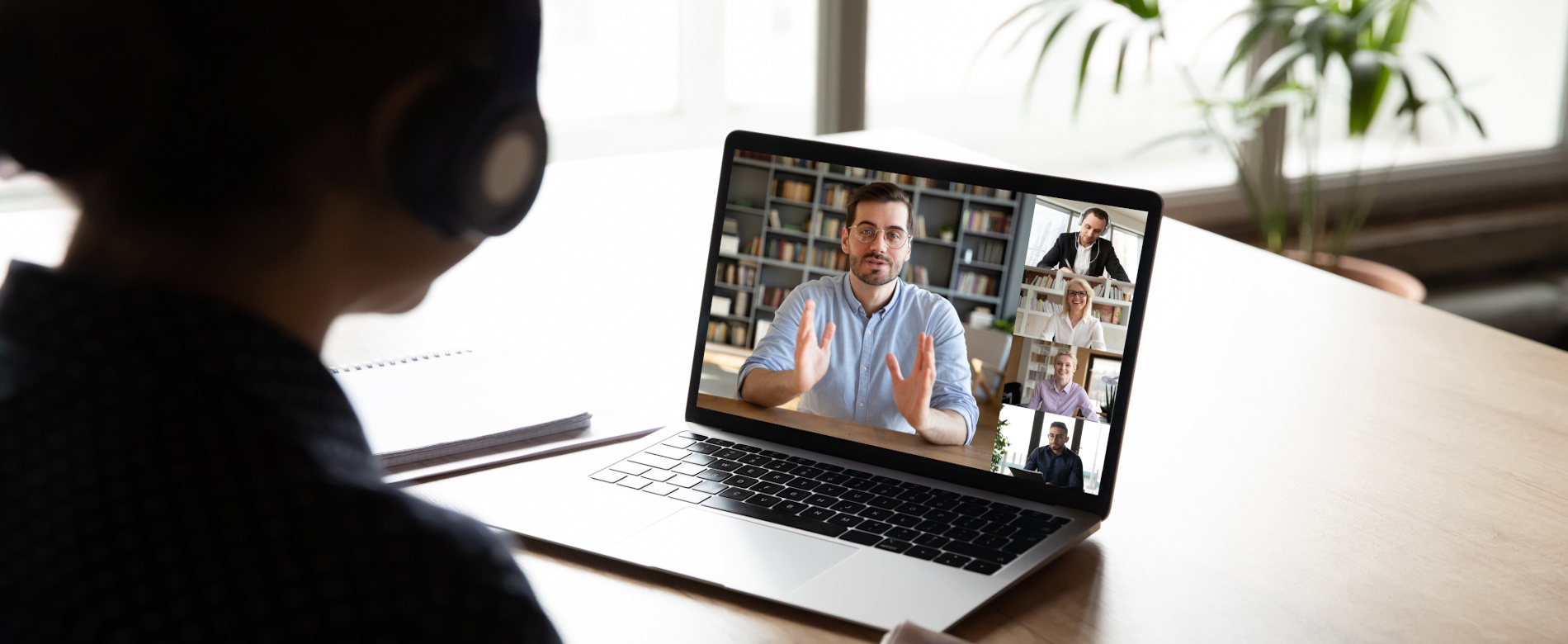 E-learning via virtual application, videocall video conferencing activity, colleagues working together concept. Pc screen view over woman shoulder, listen tutor gain new knowledge noting information